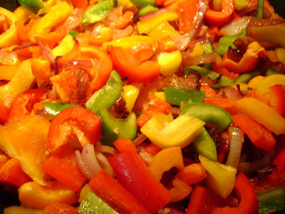 bell peppers added to the onions in the frying pan