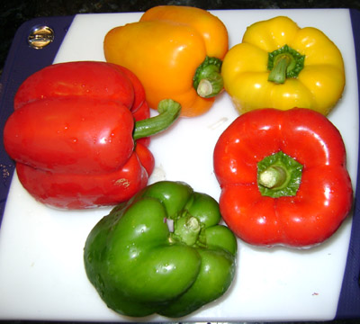 colorful red yellow and orange bell peppers, ready to be sliced