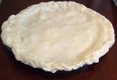 Blueberry pie is covered with the dough for the top crust
