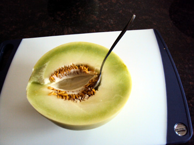 how to cut a melon - scooping out melon seeds with a spoon