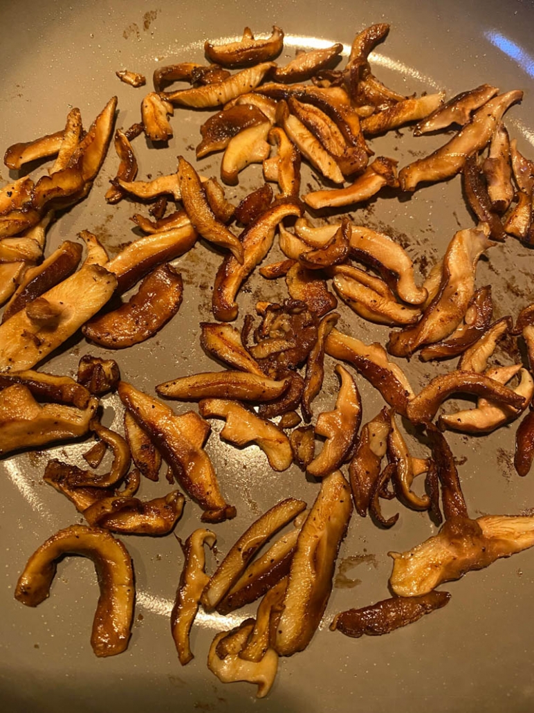 shiitake mushrooms cooking on a frying pan