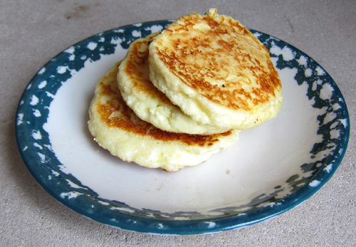 Three pieces of Russian Cheese Pancakes place on a plate.