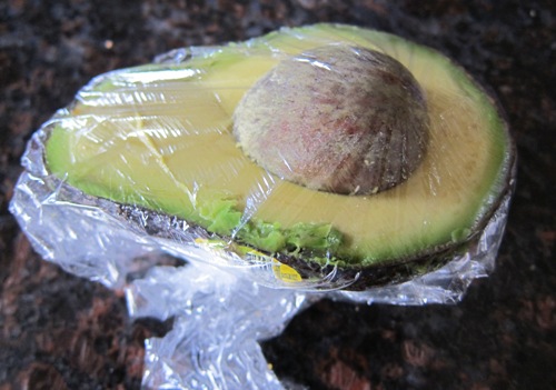 avocado half wrapped in plastic wrap for storage