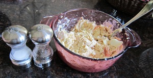 adding salt and pepper to the chicken salad