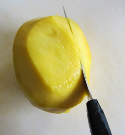 cutting a mango with a knife