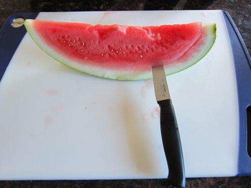 cutting off the peel of the watermelon