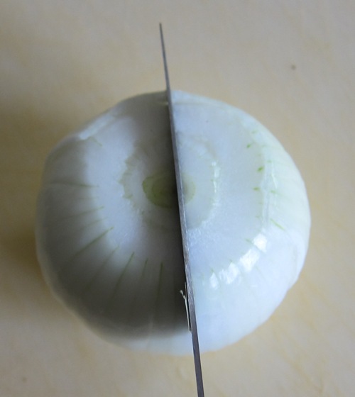 cutting onion in half with a knife