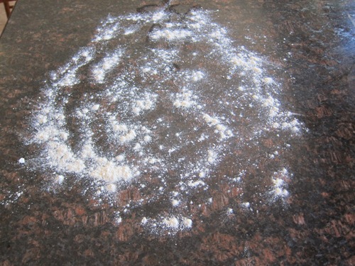 counter sprinkled with flour before rolling dough on it