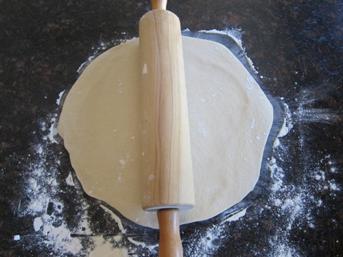 rolled pizza dough and a rolling pin
