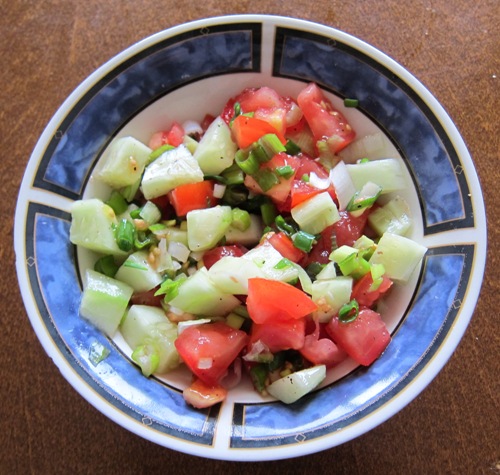 bowl with salad of tomatoes, cucumbers and green onions