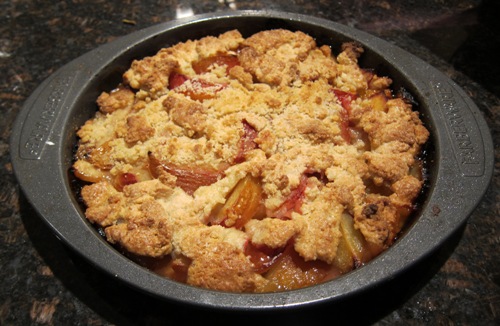 freshly baked plum pie in a baking dish