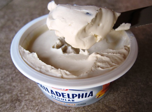 Spreading cream cheese with a knife