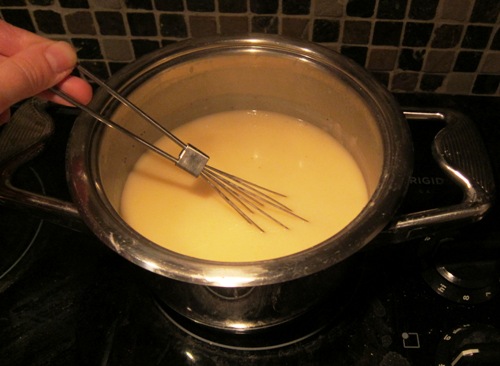 whisking the gravy on the stove