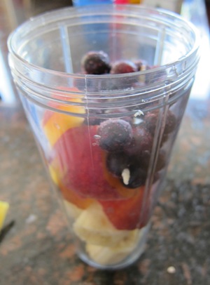 banana, blueberry and peach slices in a blender for a smoothie