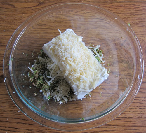 adding parmesan cheese to stuffed mushrooms filling