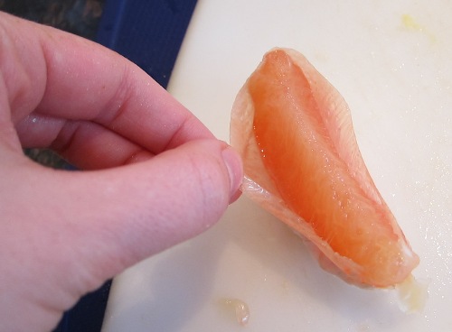 peeling skin off of grapefruit segment