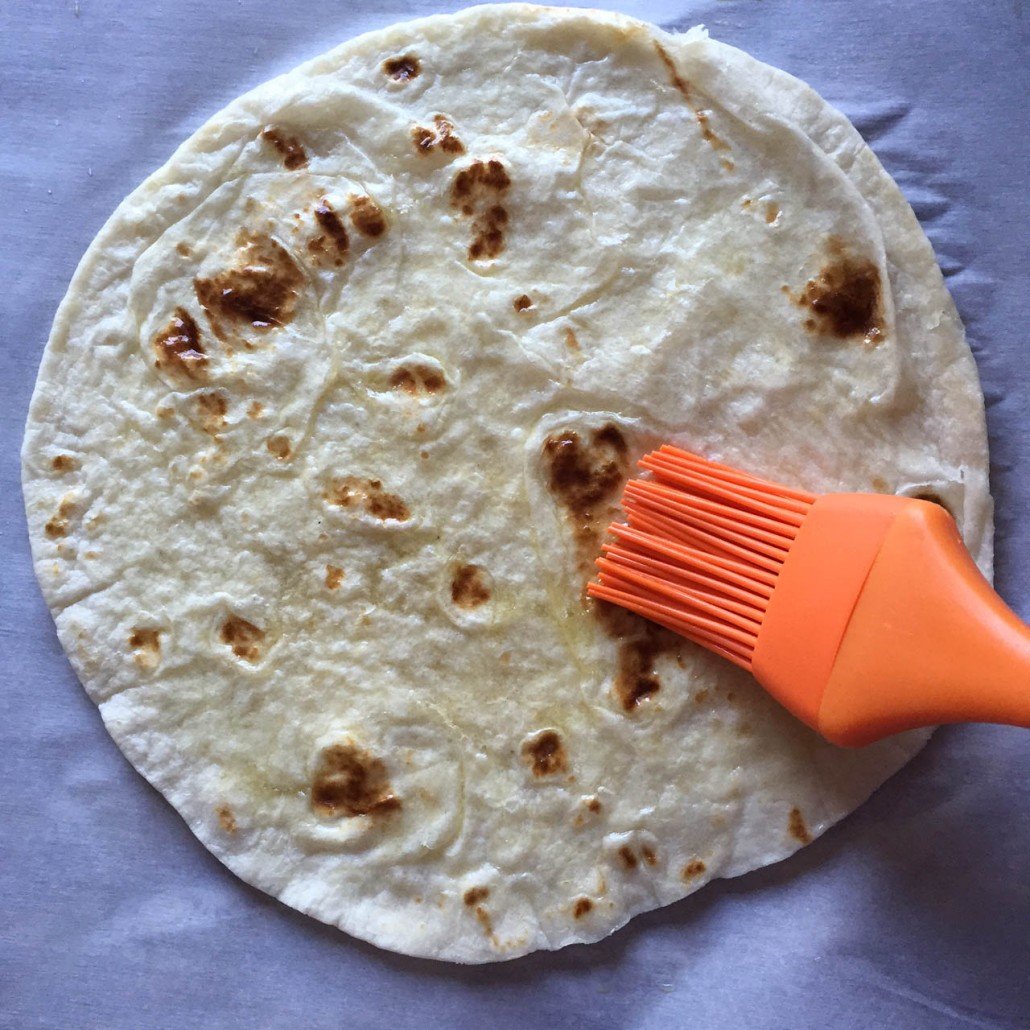Brushing the tortilla with oil
