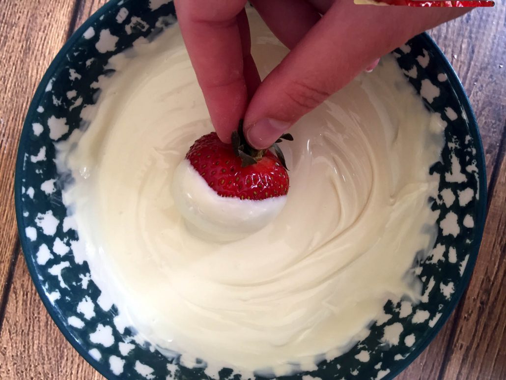 Dipping Red Strawberry In White Chocolate