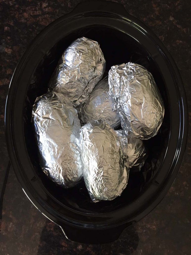 Foil wrapped potatoes in a slow cooker