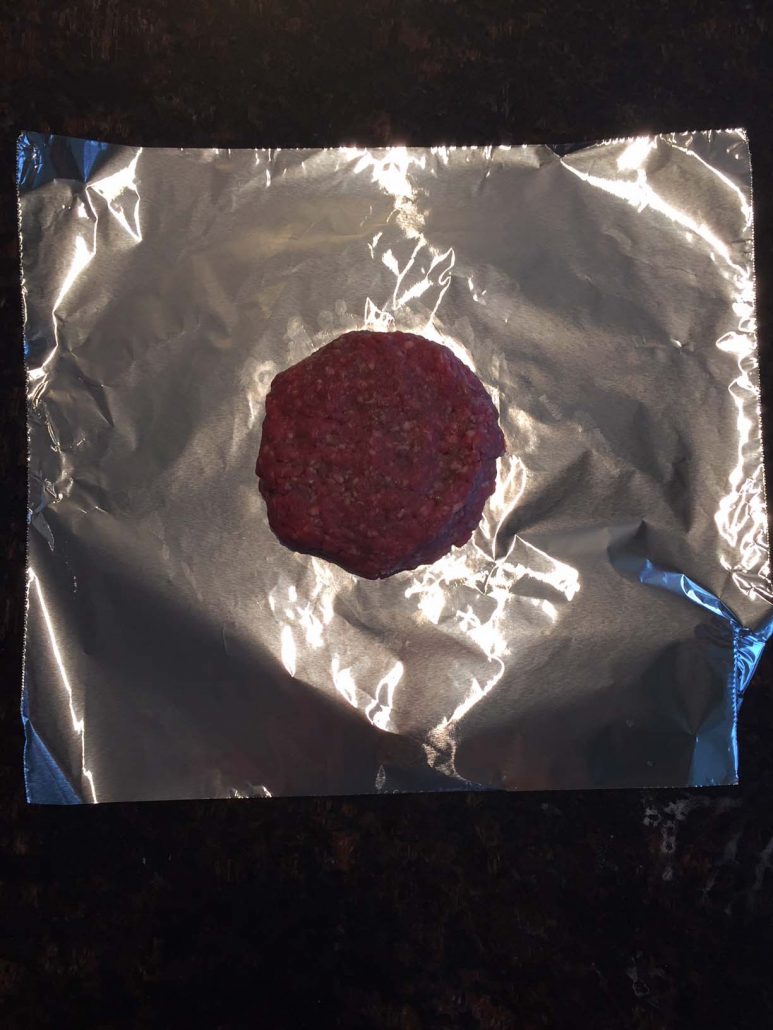 Hamburger patty on foil