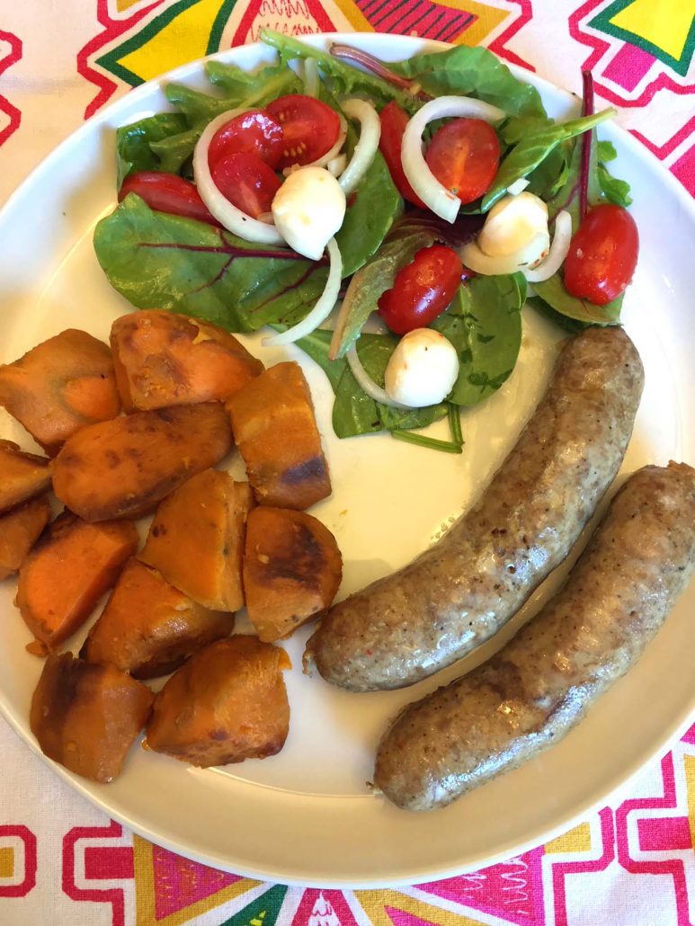 Sausage and sweet potatoes dinner with a side salad of tomatoes fresh mozzarella