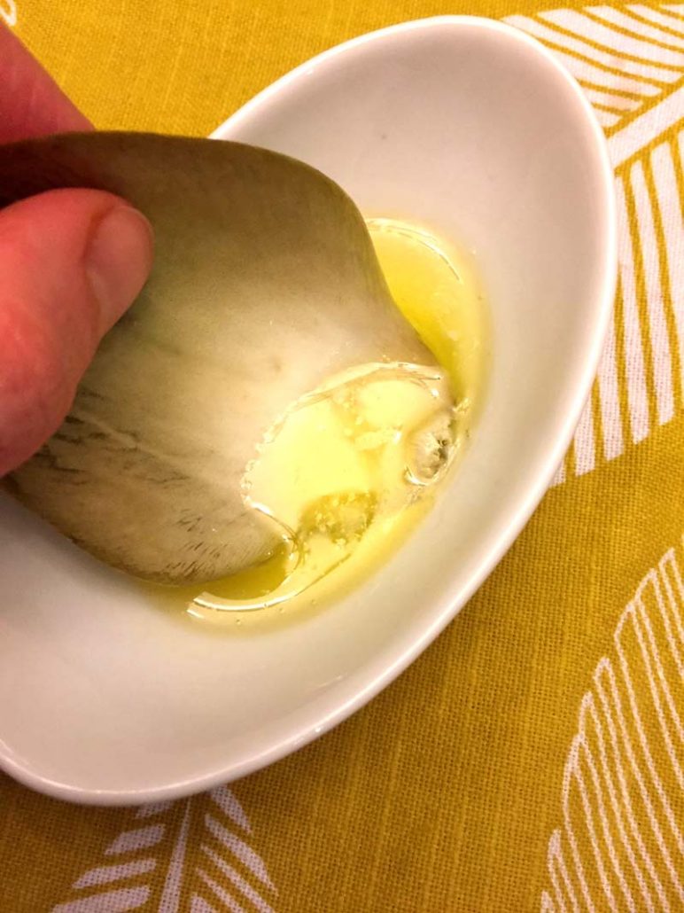 Dipping artichoke leaf in melted butter