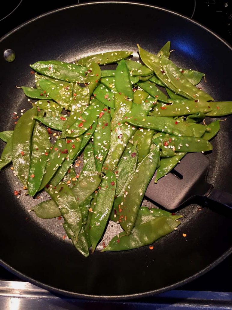 Spicy Garlic Sesame Snow Peas In A Frying Pan