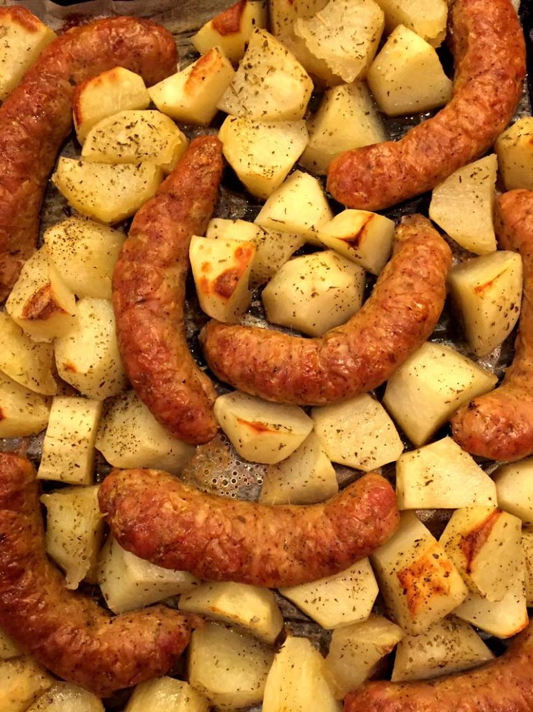 Sausages and potatoes on a baking sheet