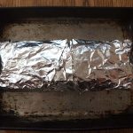 Chicken roll in foil on baking sheet