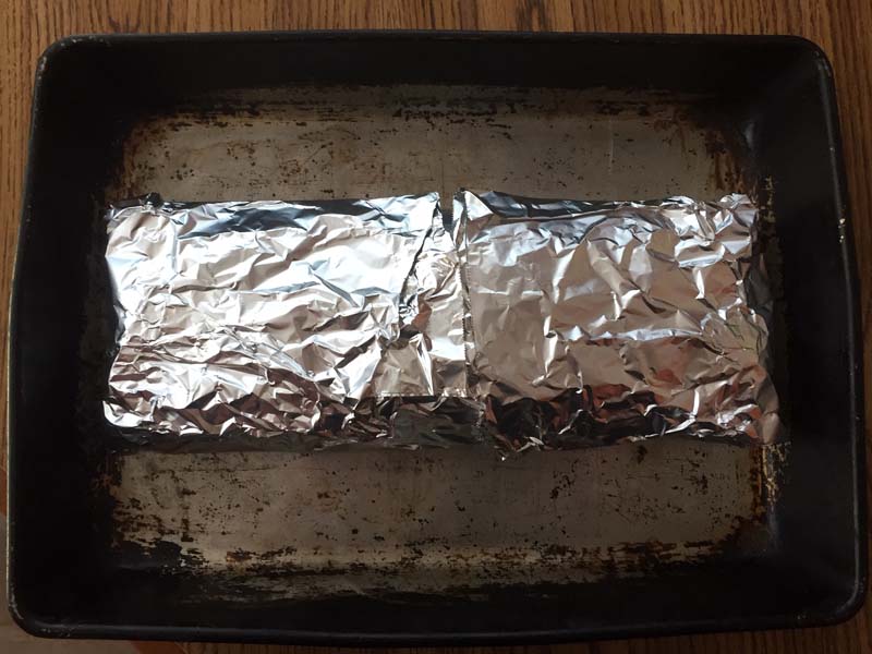 Chicken roll in foil on baking sheet