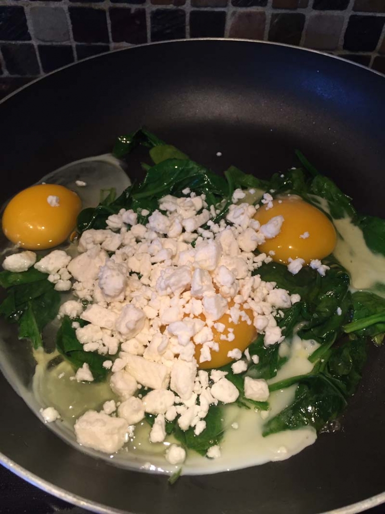 eggs and feta cheese on frying pan