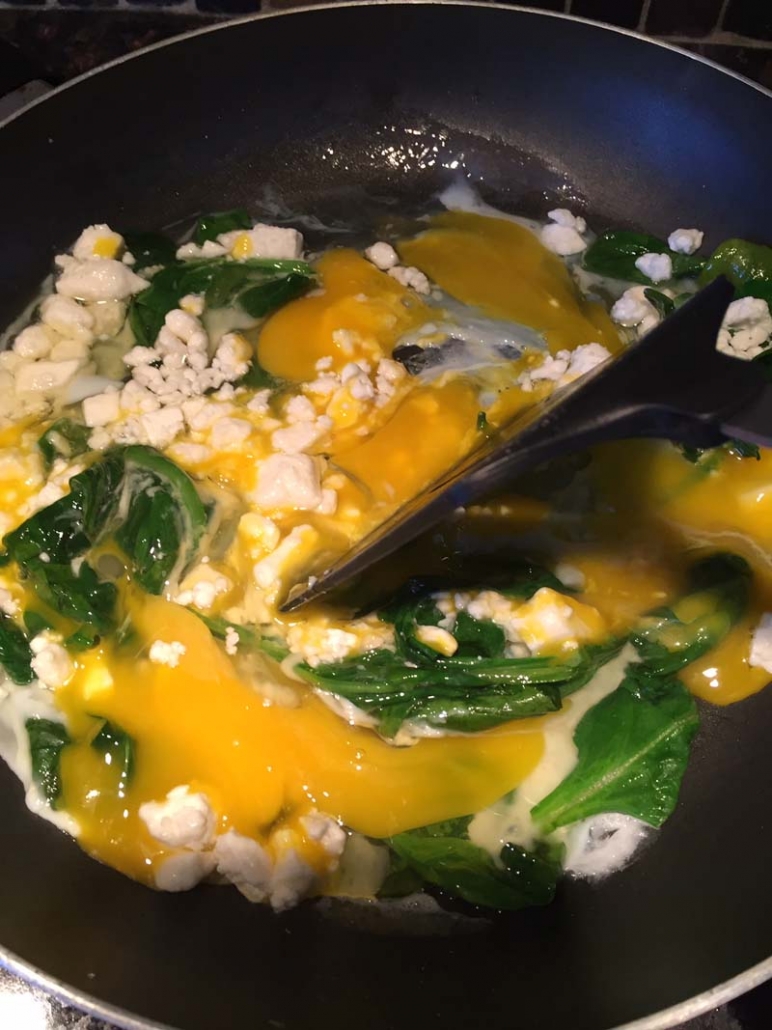 making scrambled eggs with feta and spinach