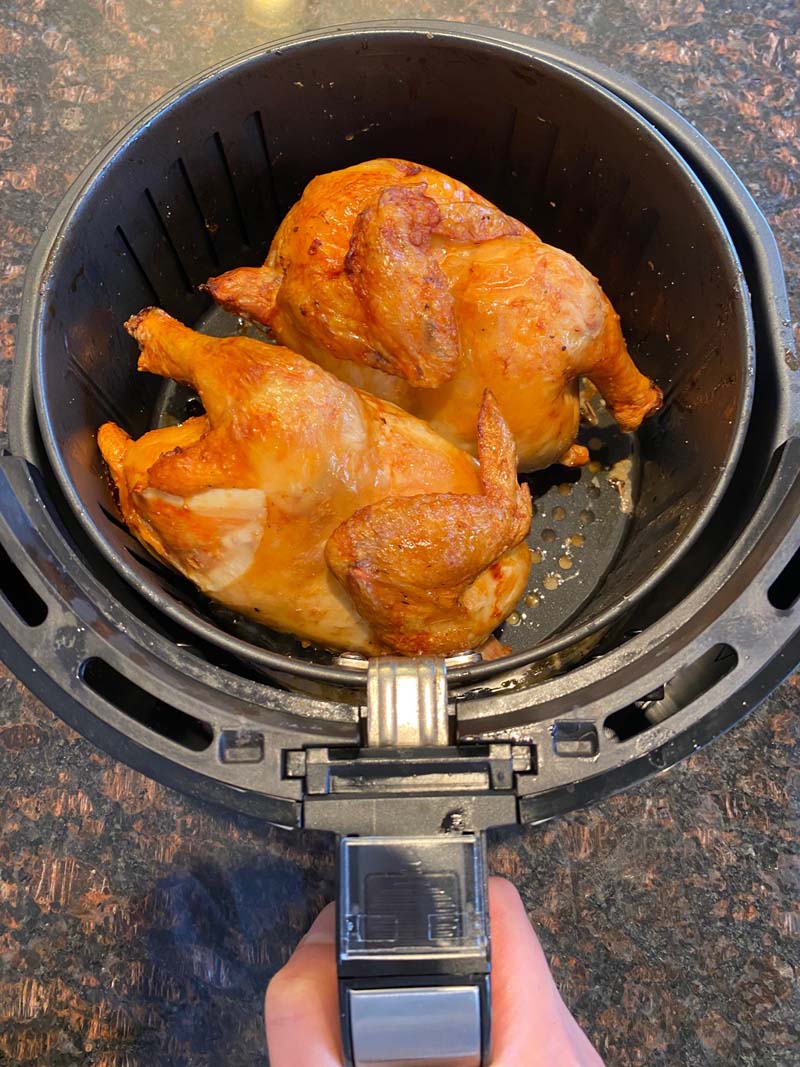 Air fryer basket filled with two cornish hens