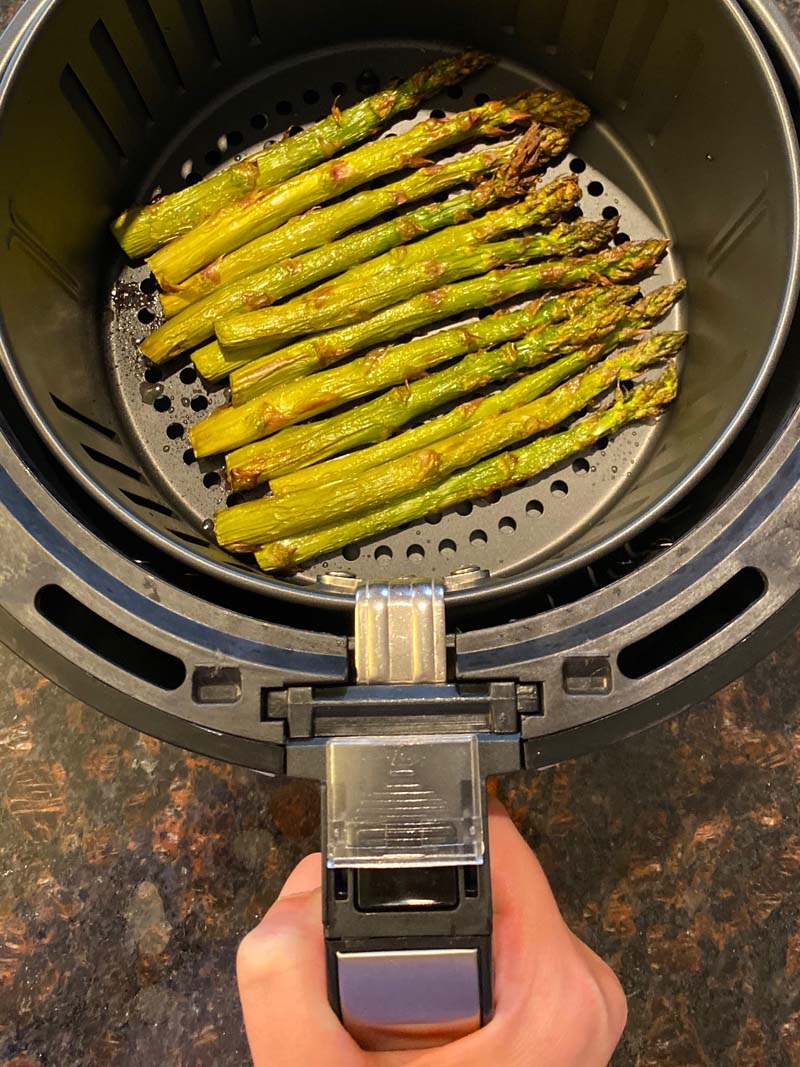 asparagus being pulled out of the air fryer