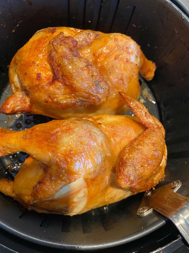 Two cornish hens in an air fryer basket