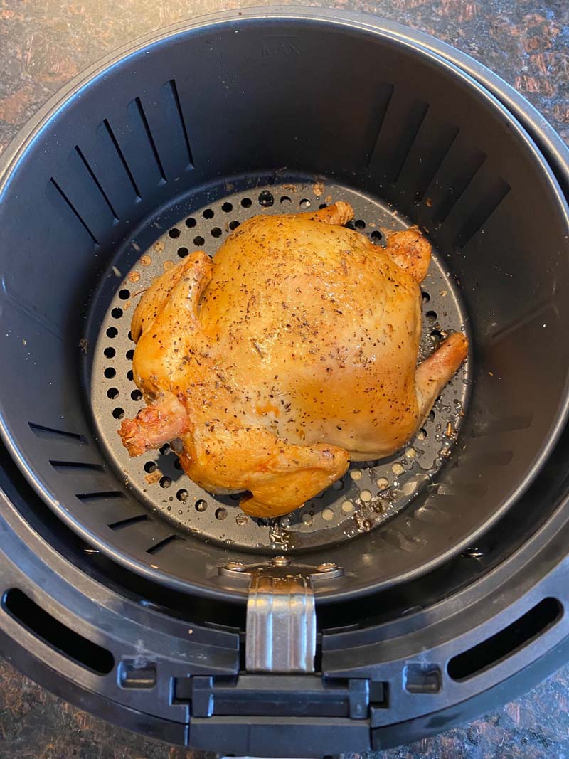 whole roasted cornish hen at the bottom of air fryer basket