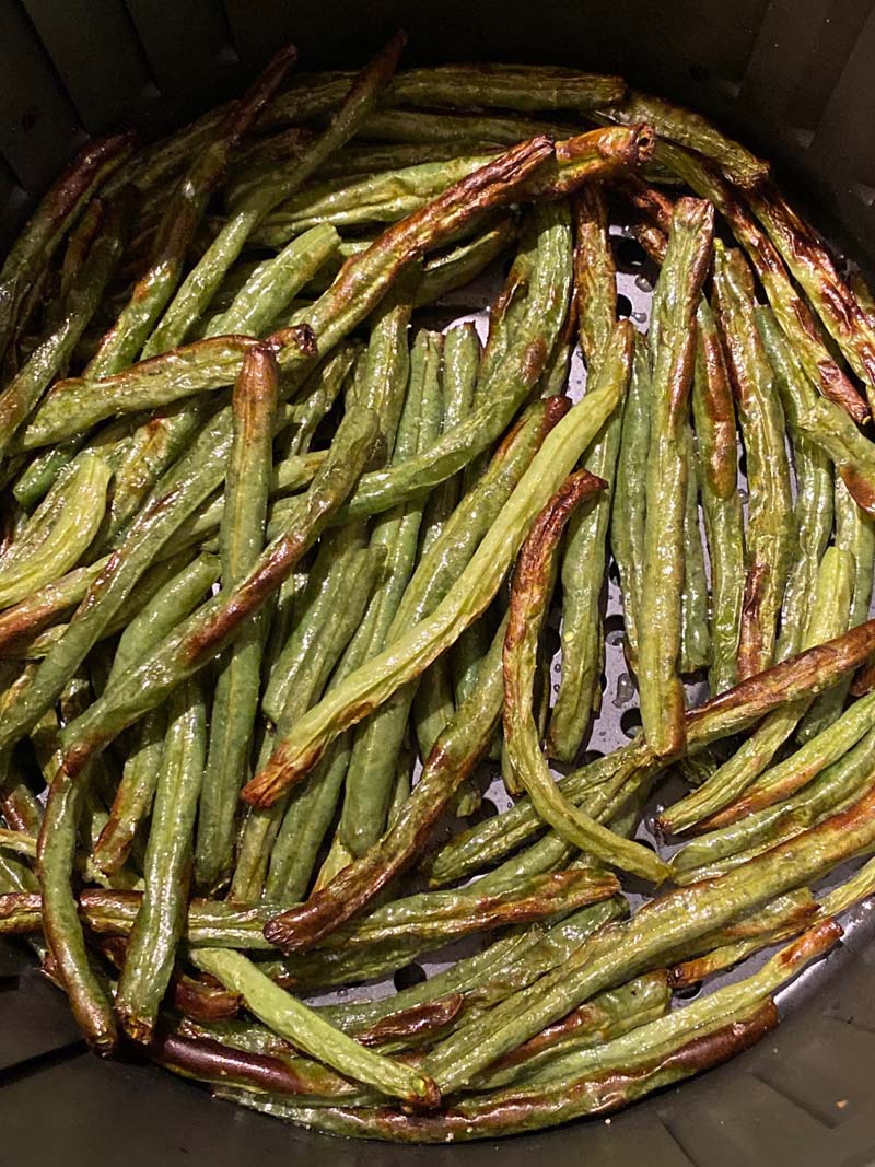 Close up of roasted green beans in an air fryer 