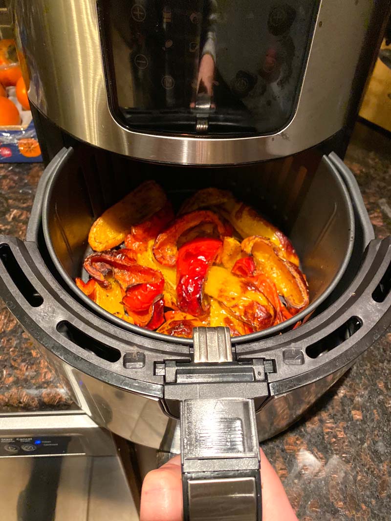 Roasted bell pepper pieces coming out of an airfryer.