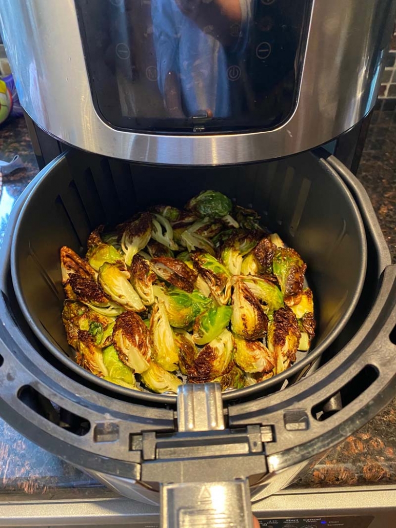 brussel sprouts cooking in an air fryer