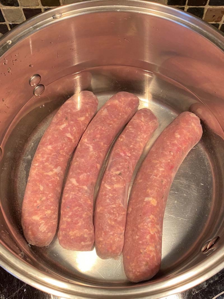 raw italian sausages in a pot of water