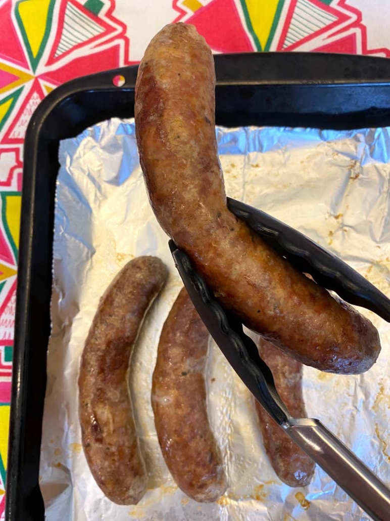 picking up an italian sausage with tongs