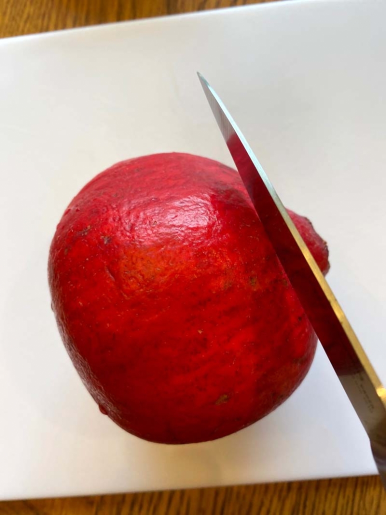 Knife cutting off the crown of a pomegranate 