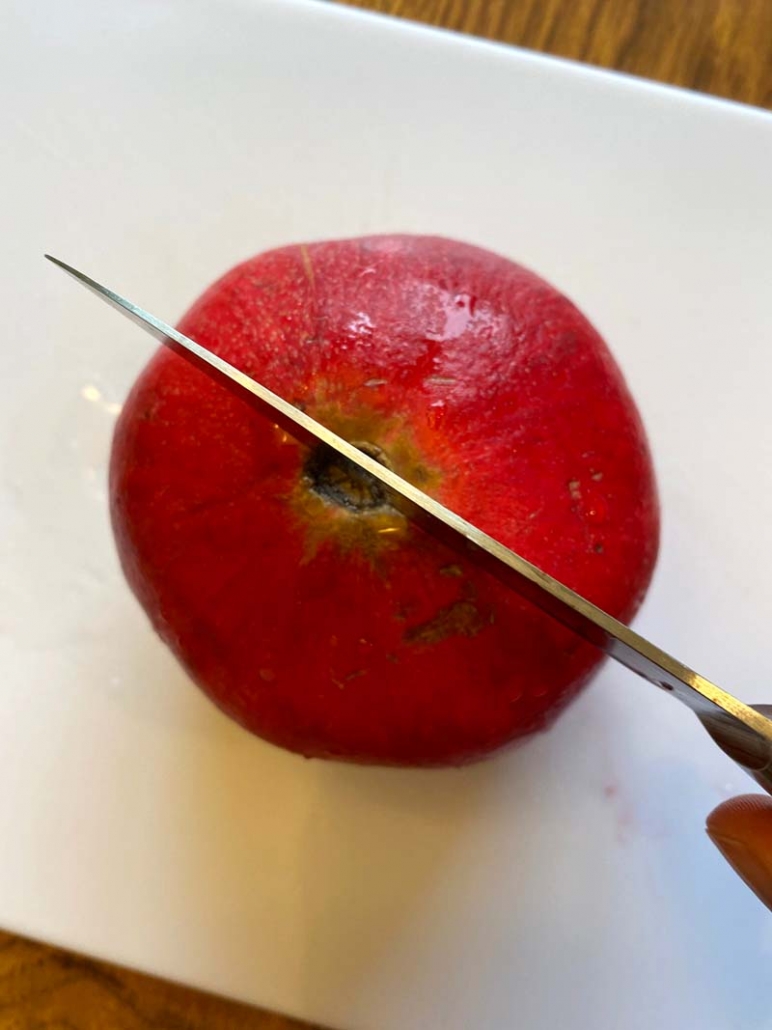 Knife slicing through a pomegranate