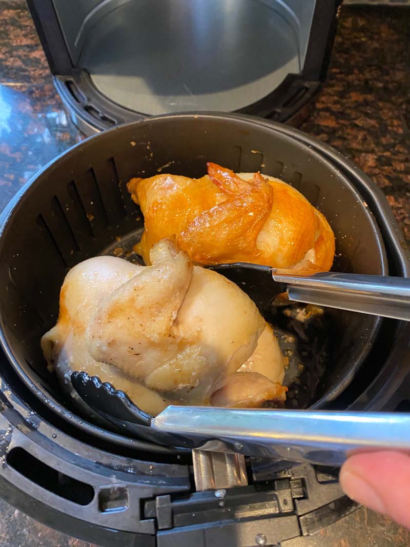 Flipping cornish hens in air fryer basket with tongs