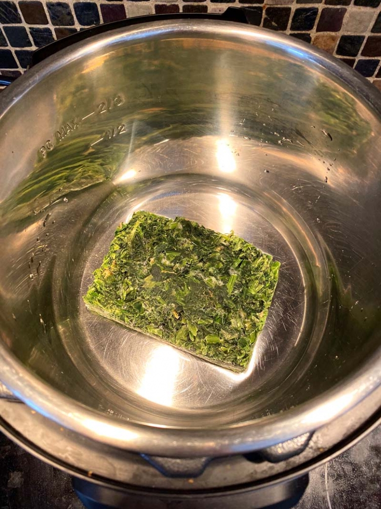 block of frozen chopped spinach in an instant pot container
