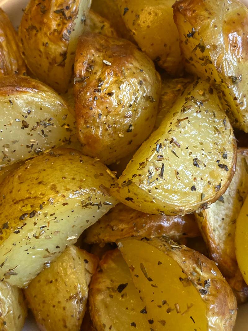Close up of roasted potatoes with skin on and herbs