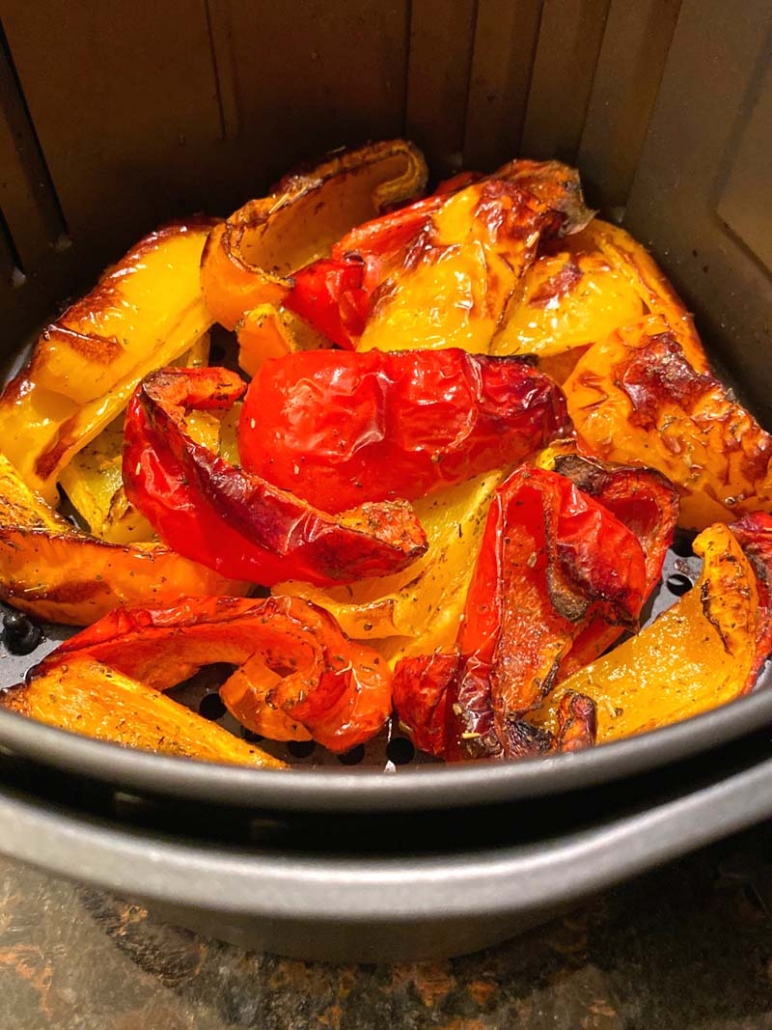 roasted bell peppers in an air fryer basket. 
