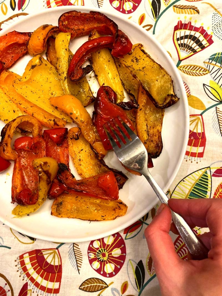 a white plate filled with red, orange, and yellow air fryer bell peppers