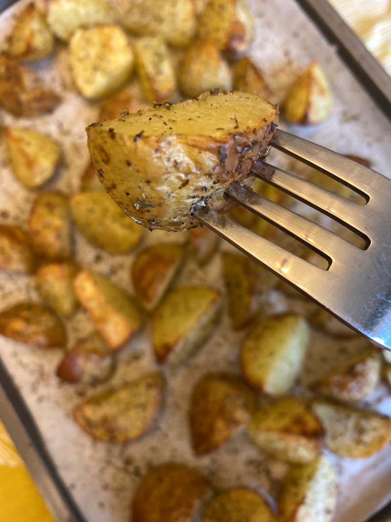 fork with a roasted potatoes with skin on the end