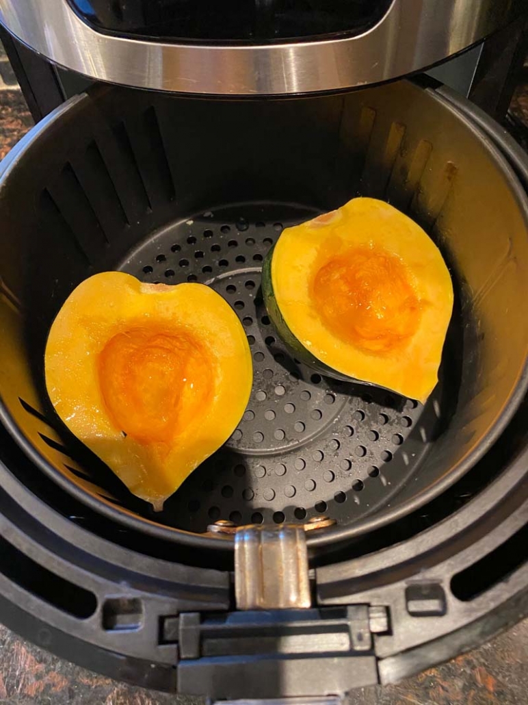 raw acorn squash halves in the air fryer basket